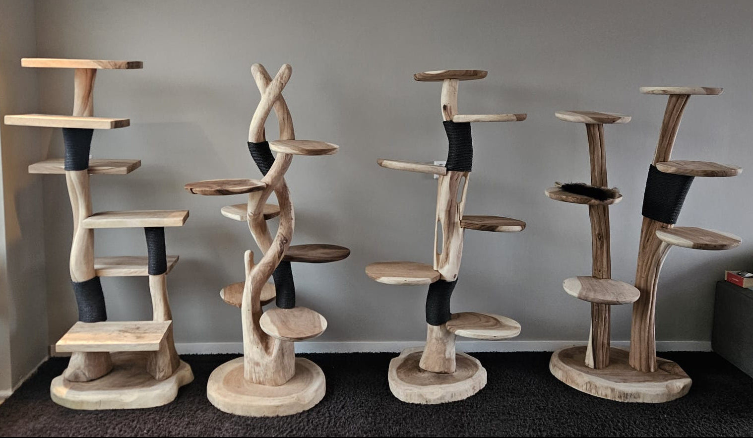 4 houten krabpalen met elk 2 a 3 plekken met zwart sisaltouw er omheen gewikkeld. 