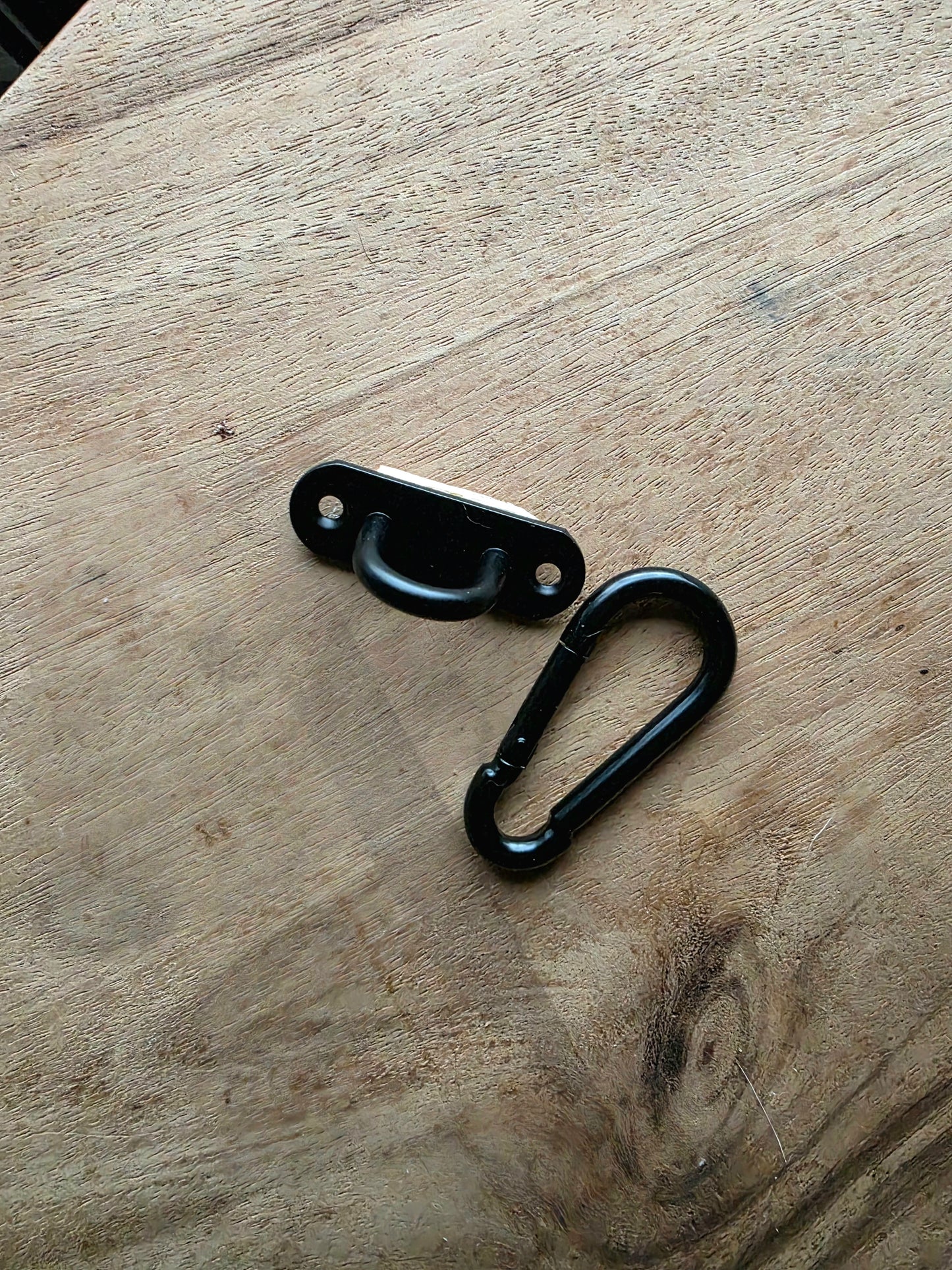 Zwarte karabijnhaak en oog om het kattenspeeltje aan een krabpaal of krabstam te bevesgtigen