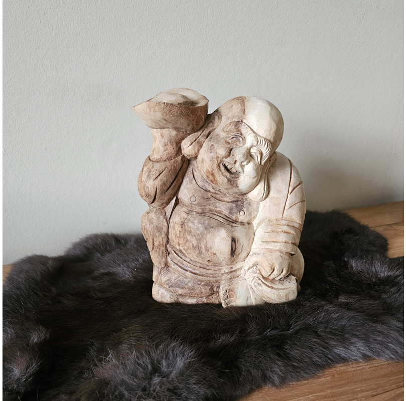 handgemaakt houten boeddha beeld op een zwart kleedje